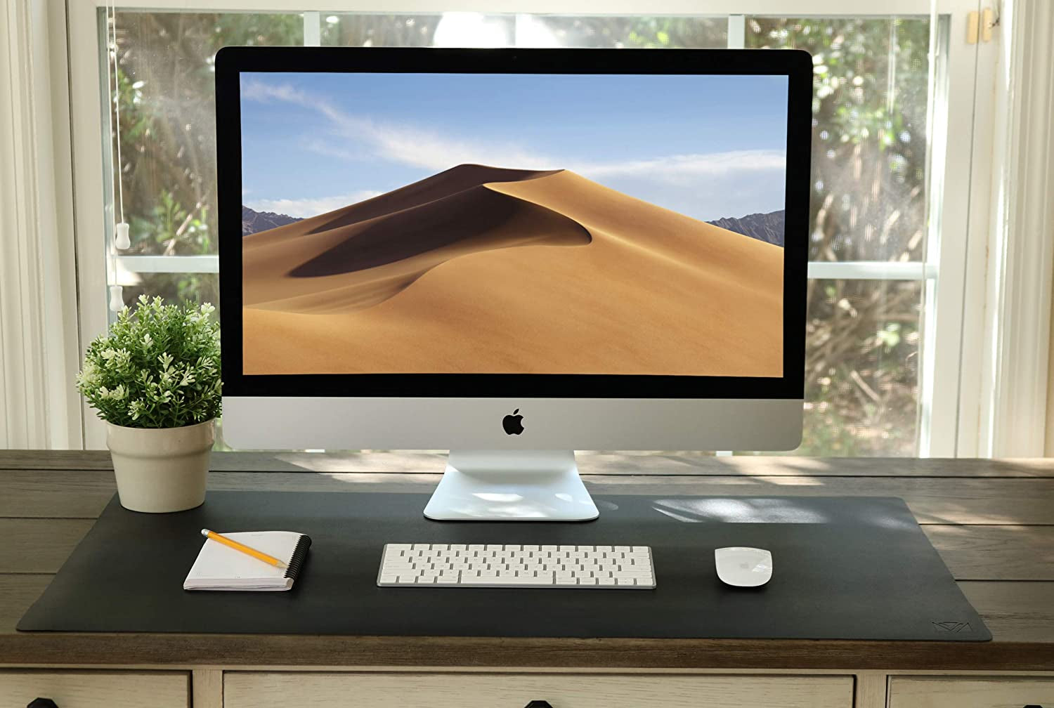 The black desk mat with a computer, a keyboard, and a mouse.